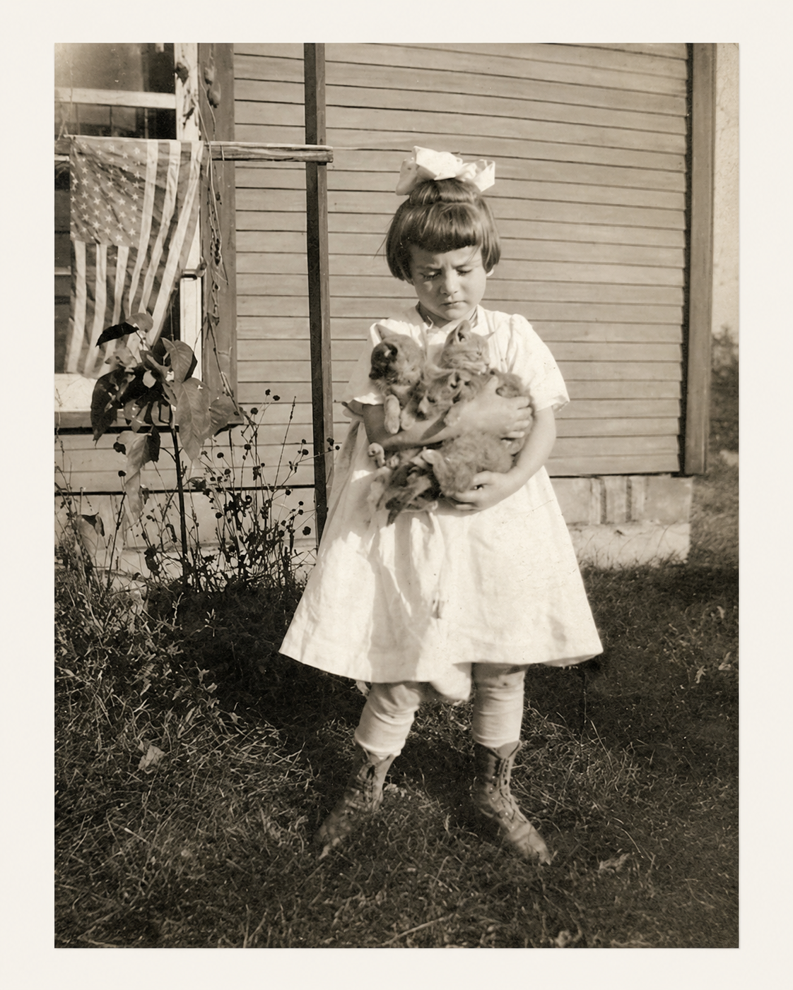 Young Jane Small standing outside holding kittens