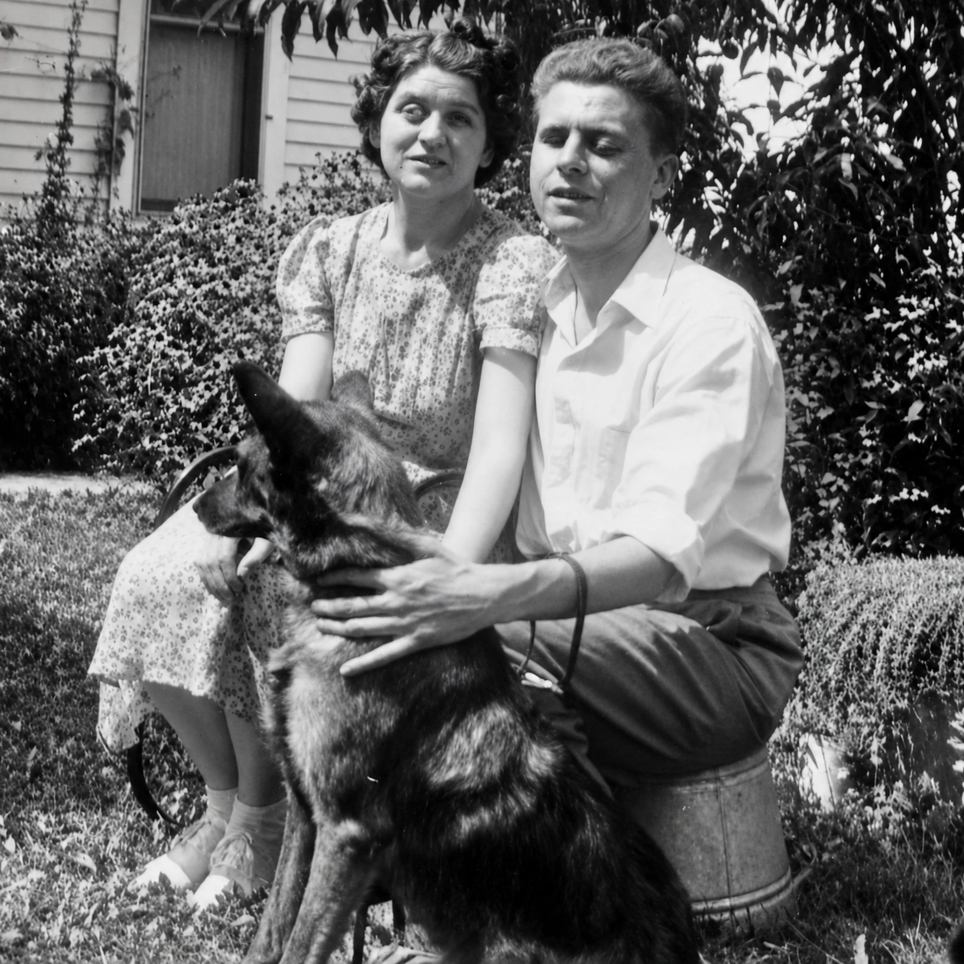 Mary Harper's parents Mario and Jane seated outdoors with their dog Admiral
